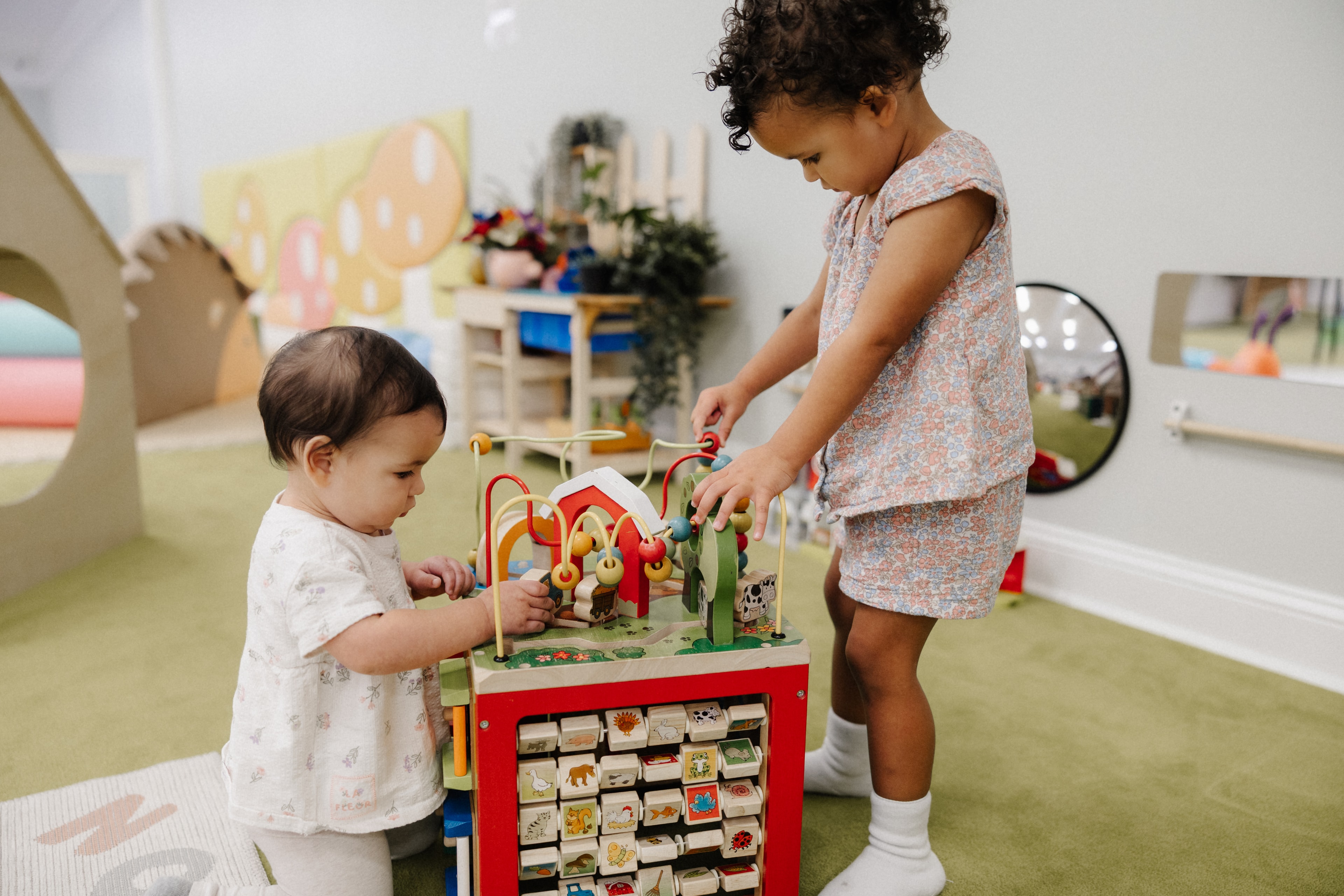 Toddlers playing with wooden activity toy