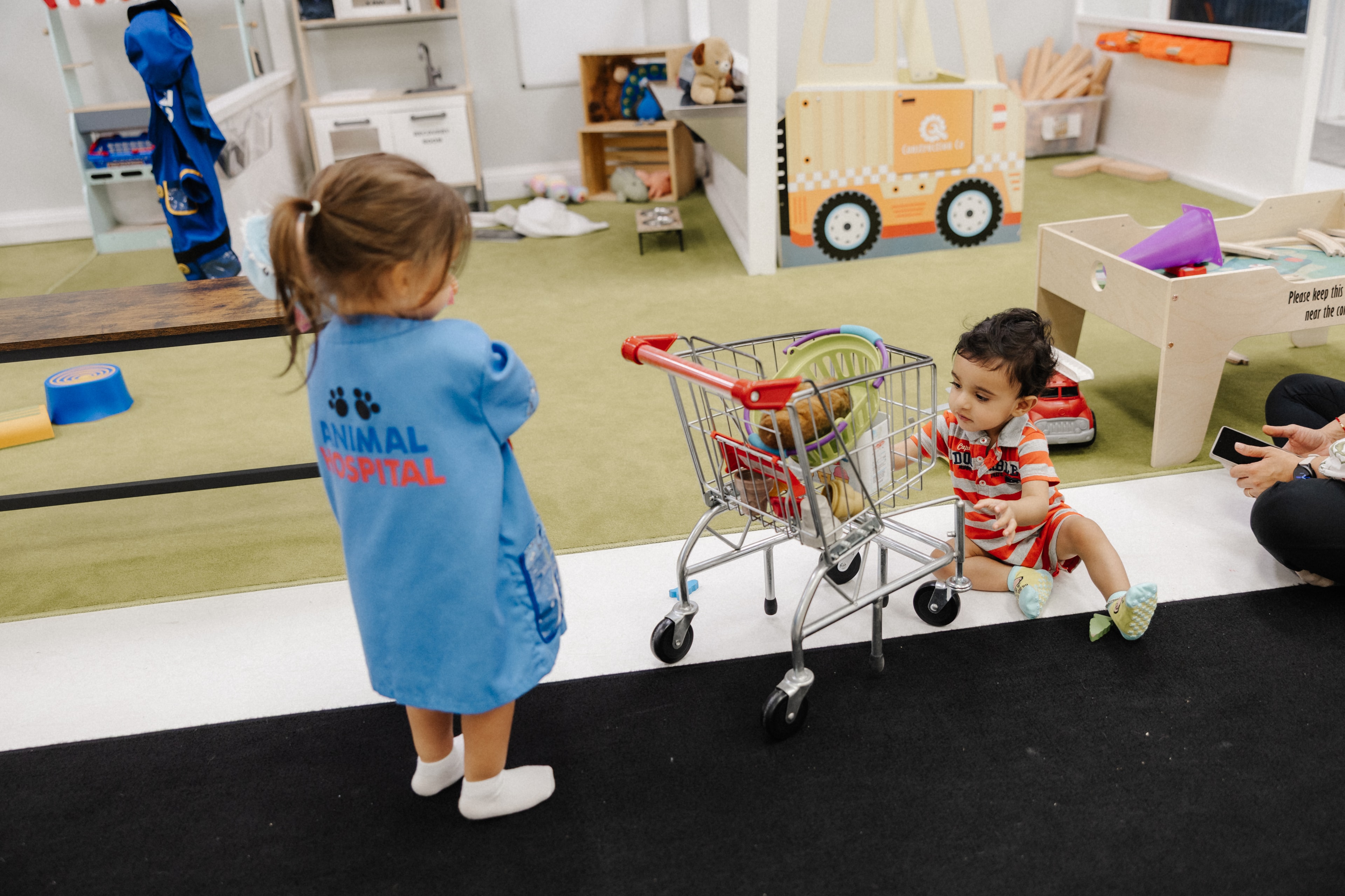 Toddlers playing with shopping cart